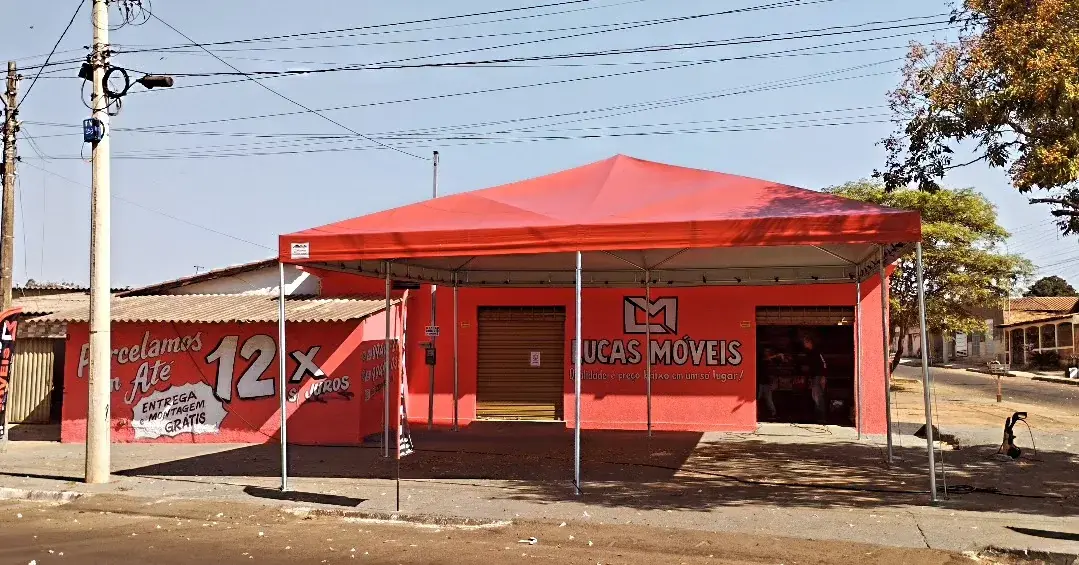 Tenda vermelha de grande cobertura instalada em frente a uma loja