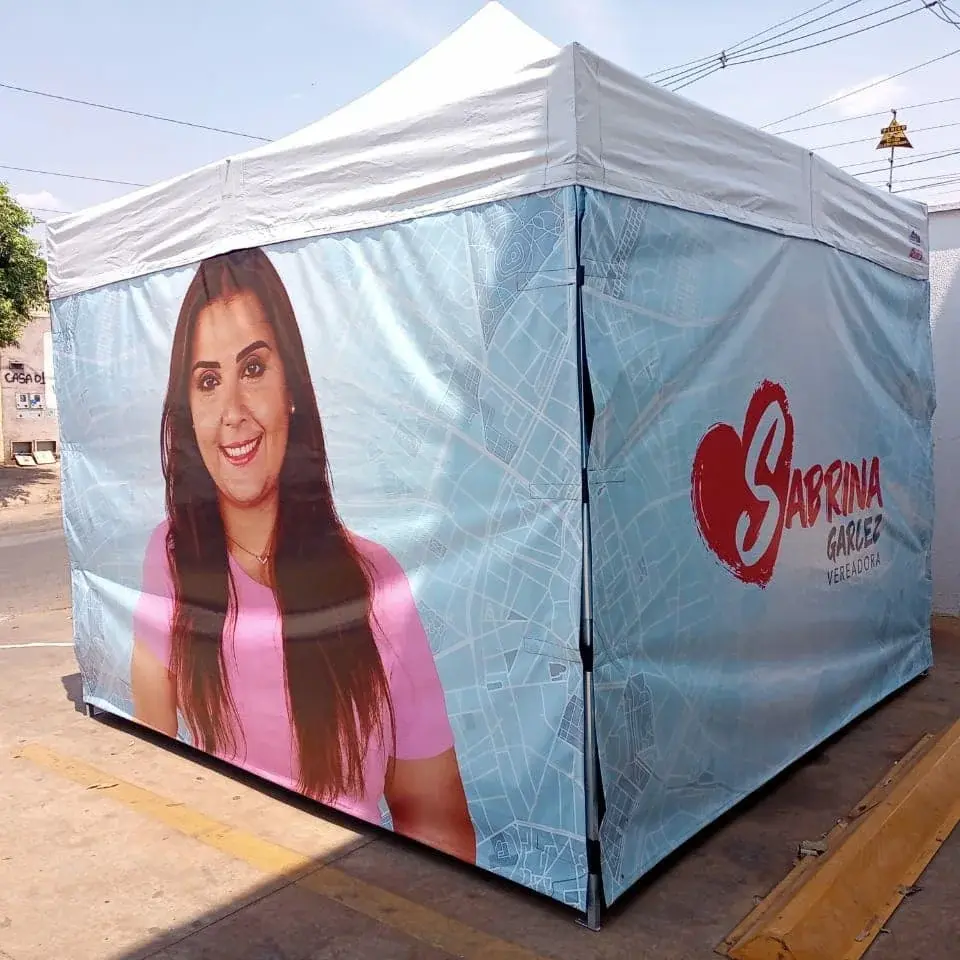 Tenda com cobertura branca e fechamentos laterais impressos vista de um canto