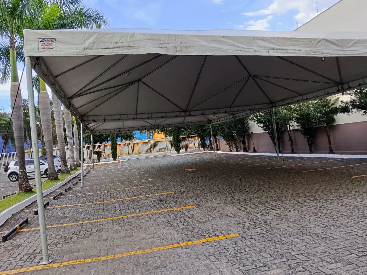 Tenda branca de grande porte cobrindo as vagas de um estacionamento