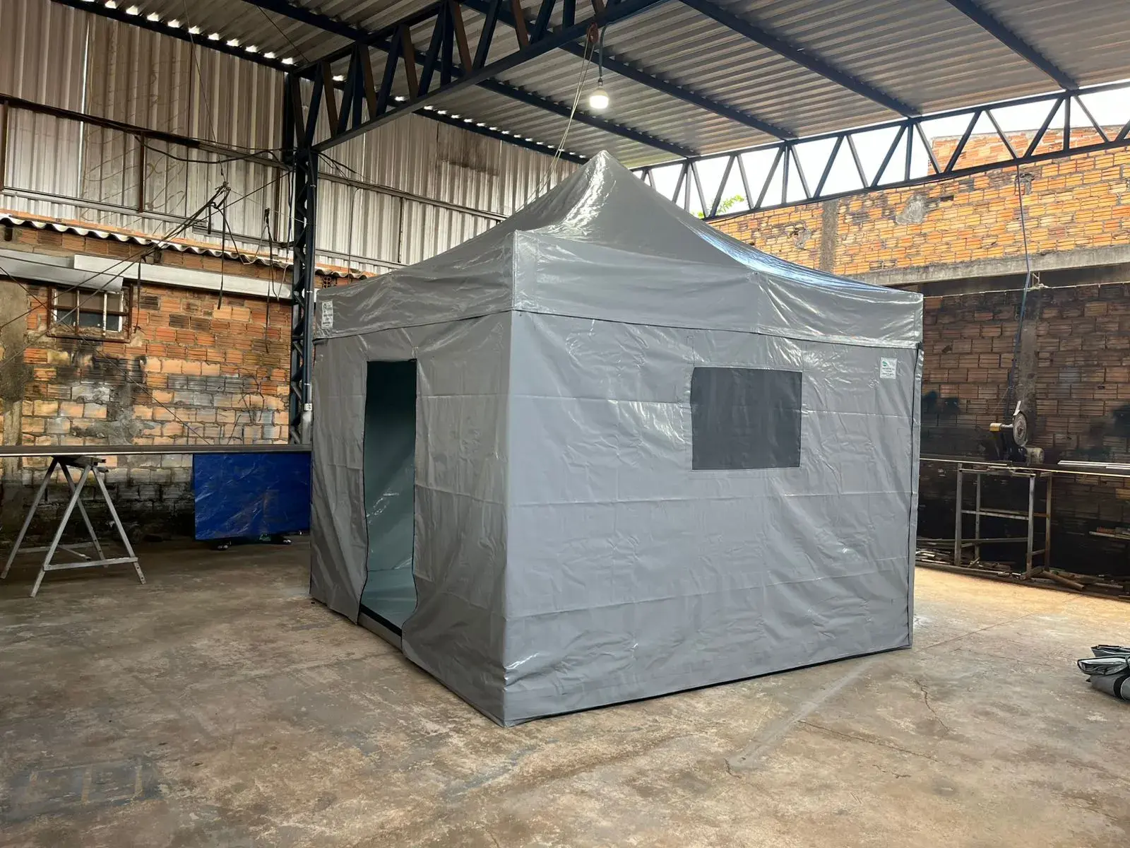 Tenda sanfonada cinza fechada, com porta e janela